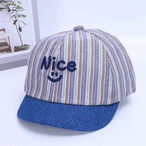 Close-up of striped baby baseball cap with Nice embroidery and navy denim brim detail
