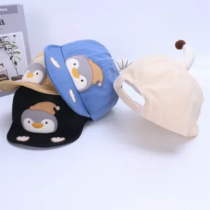 Detail of baby cotton baseball caps in black, blue, yellow, and beige with penguin embroidery