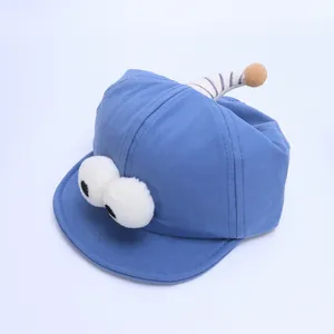 Detail view of sky blue baby baseball cap with plush big eyes and striped horns