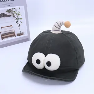 Detail view of baby baseball cap featuring cartoon plush eyes and striped antennae