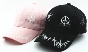 Dettaglio di cappellini da baseball rosa e neri con motivi artistici graffiti bianchi