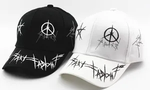 Dettaglio ravvicinato di motivi graffiti su cappellini da baseball in cotone bianco e nero