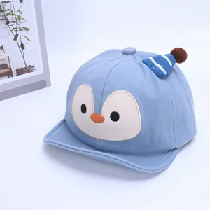 Dettaglio del berretto da baseball neonato azzurro con ricamo pinguino e pompon