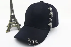 Détail d'une casquette en coton noir avec anneaux métalliques et chaîne décorative