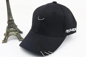 Détail d'une casquette en coton noir avec anneaux argentés et broderie japonaise