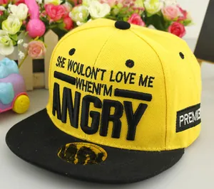 Detail of yellow flat brim baseball cap with bold black embroidery and gold seal label