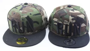 Détail de casquettes de baseball camouflage avec broderie RUN 3D et visière plate noire