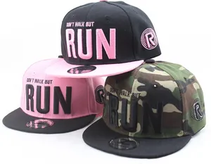 Détails de trois casquettes snapback camouflage et roses avec broderie RUN et écussons ronds