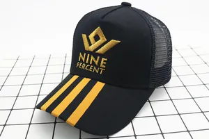 Detail of embroidered Nine Percent logo on black and yellow mesh trucker baseball cap