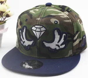 Detail shot of camo snapback cap with diamond and glove embroidery on plain background