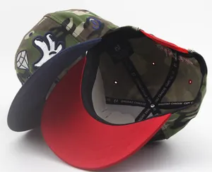 Detail of camo snapback cap lining showing white sweatband and interior reinforcement tape