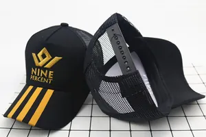 Detailed view of black mesh trucker hat with yellow embroidery and adjustable back strap
