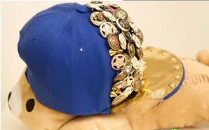 Detail of royal blue hip-hop cap featuring metallic studs, stars and mirror gold brim