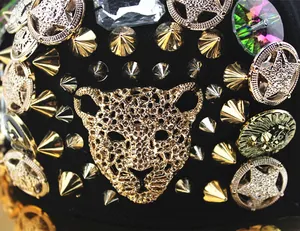 Macro detail of punk cap featuring gold leopard head, spikes, and crystal rhinestones