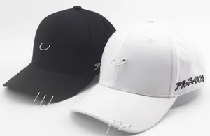 Detail view of cotton baseball caps featuring decorative metal rings and side embroidery