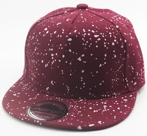 Detail of burgundy snapback cap for kids featuring white paint splatter street style texture