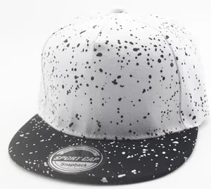Detail of snapback cap with black and white splatter design and silver laser sticker