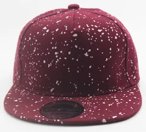 Detail of a burgundy snapback cap featuring white splatter pattern and Sport Cap sticker