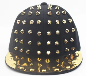 Détail de la casquette punk noire avec des clous métalliques dorés et une visière brillante