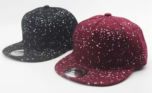 Detail of flat brim snapback caps with white splatter pattern in black and burgundy
