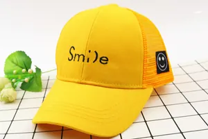 Detailansicht der Smile-Stickerei und des Netzgewebes an dieser gelben Kinderkappe