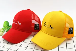 Detail der Kinder-Netz-Baseballkappe mit Smile-Stickerei und gelb-rotem Kontrast