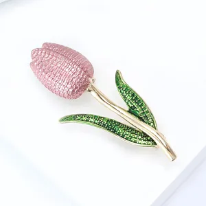 Detailed view of pink enamel tulip brooch with textured green leaves and gold edges