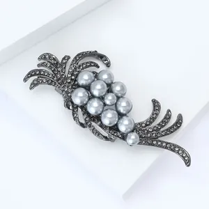 Close-up of vintage gun-black brooch with clustered pearls and crystal inlay