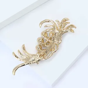 Detailed back view of golden feather brooch showing the secure pin fastener mechanism