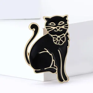 Élégante broche chat en émail noir avec contours dorés et collier floral sur support