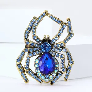 Vintage Gold-Spinne Brosche mit blauen Strasssteinen und birnenförmigem Edelstein auf Weiß