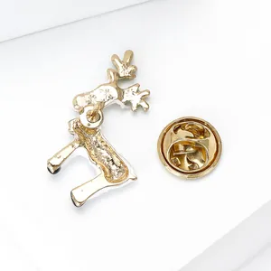Detail view showing the golden reindeer brooch back with metal butterfly clutch and texture