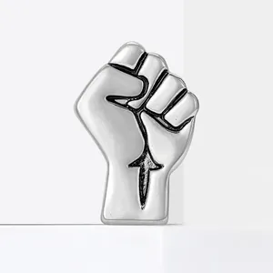 Silver fist brooch with female symbol and vintage finish on white geometric stand