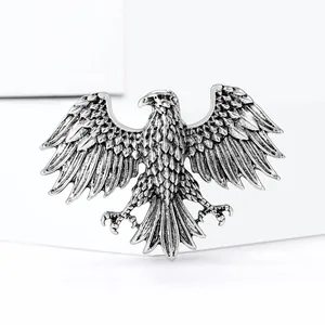 Detailed macro view of retro silver eagle brooch with intricate wing carving textures