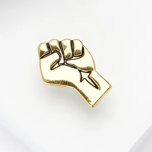 Detailed close-up of a polished gold fist lapel pin brooch on white background