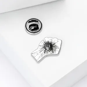 Detail view of silver fist brooch back with secure butterfly clutch and textured finish