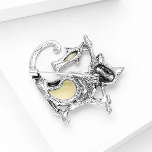 Macro shot showing the vintage silver alloy back and pin closure of the cat brooch