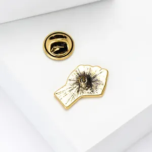 Detail view of the golden metal fist brooch back showing the pin and butterfly clutch