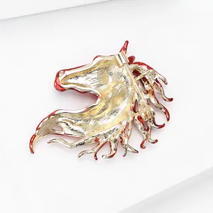 Macro view of gold horse brooch back showing secure pin fastener and red enamel trim