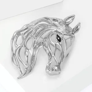Macro shot of silver hollow horse head brooch with black gemstone eye on white stand
