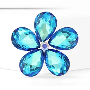 Broche fleur argentée élégante avec cinq cristaux bleus et un centre iridescent