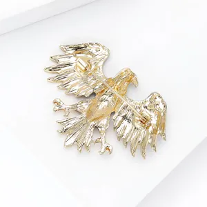 Detailed back view of golden eagle brooch showing textured metal and secure pin clasp