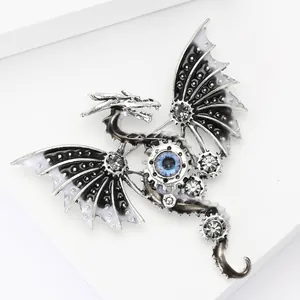 Detail of mechanical dragon brooch with gear elements and a blue eye on white props