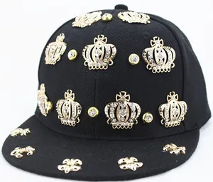 Close-up of black hip-hop cap with gold crown studs, rhinestones and fleur-de-lis details