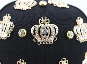 Macro shot of gold crown emblems with sparkling rhinestones on black hip-hop baseball cap