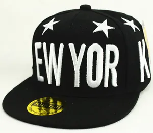 Detalle de gorra de béisbol negra infantil con bordado New York y sello dorado premium