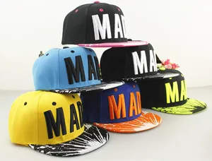 Detalle del bordado MAD y textura de pintura en viseras planas de gorras tipo snapback