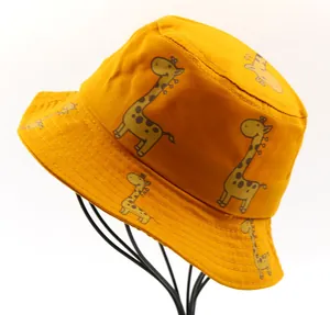 Detail of yellow cotton kids bucket hat with giraffe print on a wire stand