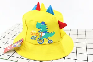 Detailed view of yellow kids dinosaur bucket hat with 3D colorful spines and cartoon print
