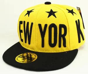 Detalle del bordado de New York y patrón de estrella en gorra de béisbol amarilla y negra
